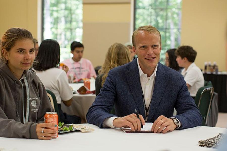 President Trey Devey eats lunch with high school students.