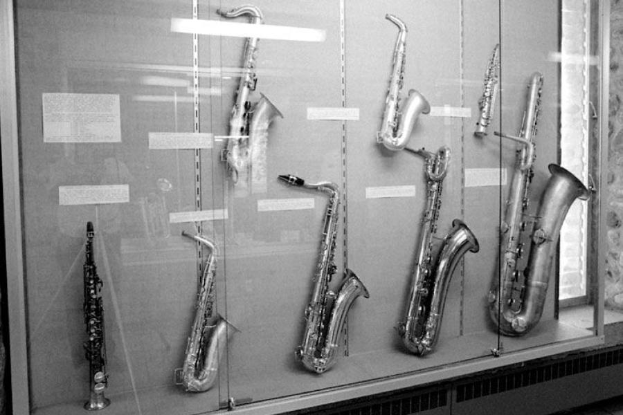 A collection of saxophones in a glass case